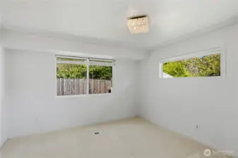 Spacious primary bedroom with large windows and natural light.