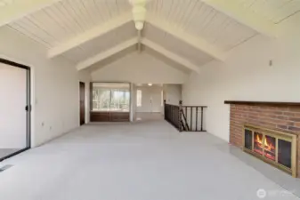 Living room with vaulted ceiling and access to deck