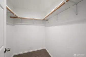 The walk-in closet in the primary bedroom is spacious and there is a lot of hanging space.