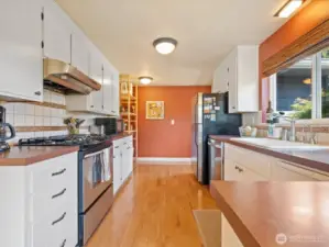 Lovely Kitchen with wood floors, stainless appliances, lots of counters & cabinets, & view window out the front.