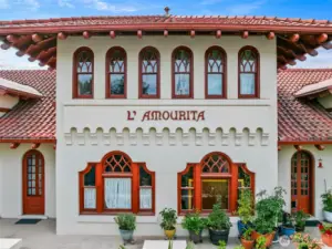Charming arches and red-tiled eaves, a warm and timeless welcome to historic L’Amourita—Seattle’s cherished 1909 treasure.