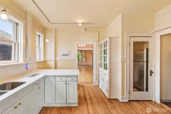 Original glass-front built-ins add authentic 1909 craftsmanship to this updated kitchen space.