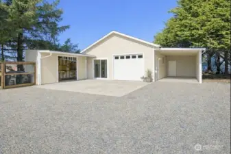 Detached single car garage with a carport and storage shed.