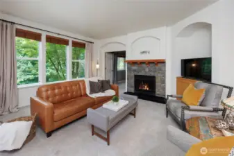 Family room features a cozy fireplace, walls of windows & Main floor den/guest room.