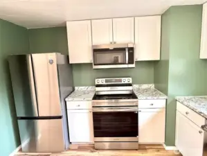 Kitchen with new refrigerator, stove, microwave, and cabinets