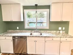Kitchen with new dishwasher, sink and cabinets.
