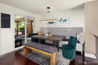 This stylish dining nook features custom built-in bench seating, a rustic wood table, and plush velvet chairs for a cozy yet modern vibe. Sliding glass doors open to a covered patio, extending your entertaining space outdoors. A perfect blend of comfort and function.