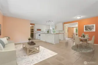 Step inside and you’re greeted by living room walls in autumn shades that balance cozy and bold, paired with a white-on-white kitchen that plays it clean. The island gives you a seat for coffee or chats with the cook, and French doors lead you into the next room with a little drama.