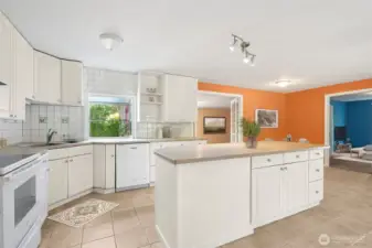 Square white tile is a classic move, but here it’s done right, running floor-to-ceiling so the kitchen feels finished. The glass-topped electric stove adds to the clean lines, and you skip the natural gas debate entirely. It’s simple, safe, and polished.