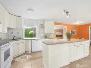 Square white tile is a classic move, but here it’s done right, running floor-to-ceiling so the kitchen feels finished. The glass-topped electric stove adds to the clean lines, and you skip the natural gas debate entirely. It’s simple, safe, and polished.