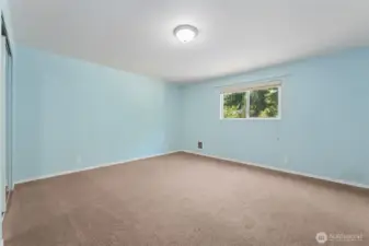 At roughly 15'x15', this bedroom gives you real square footage to work with. Mirrored closet doors double as full-length fit check central or your own dance studio. The barely-there blue walls keep it light, while warm latte carpeting makes the room feel grounded.