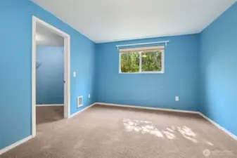 Sky blue and baby blue walls give this smaller bedroom some personality, while dark latte carpet grounds it. The walk-in closet is the surprise here, turning the “smallest room” into one that actually pulls its weight. Ideal for a guest space, craft room, or a dedicated Zoom zone.