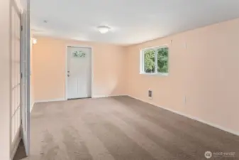 Behind the French doors is a flexible 23-foot room with dark latte-toned carpet, apricot-butter walls, and white trim. A second exterior door with an arched accent window ties in the design. Call it a huge bedroom number three or call it a great sized family room, either way it’s the kind of bonus space that makes the floorplan work smarter, not harder.