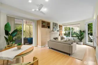 Coming off the main hallway looking into the dining and living areas. Here you can see the slider to the side patio, the gas fireplace windows and door to the primary patio. This patio has built up gardens and view toward the I-5 Bridge. Also a great place for the BBQ Notice how much natural light this room receives.