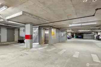 This view from the garage is showing the stairway and elevator. The white doors on the left are individual storage rooms for each home.