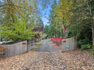 Electronic gate with keypad & remote greets you as you arrive at this amazing property.  Drive is lined with mature landscaping for year round color.