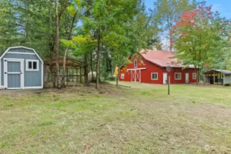 Shows newly finished chicken coop,40x60 barn with 2-3 stalls, heated tack room and 20T hay loft. Covered horse washing station just to the right.