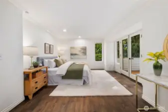 The expansive primary suite also features French doors to the deck outside