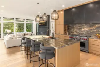 Chefs Kitchen highlighted by large island with stunning designer selected slap counter top and backsplash