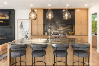 Custom designed and fabricated blackened steel hood accentuated in a full height fireplace surround blackened steel detail. Sleek and contemporary luxury
