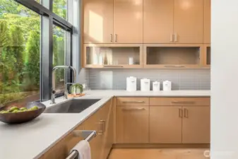 Skullery prep kitchen off the main kitchen includes more custom cabinetry with slab counter prep space, tile backsplash, second Cove dishwasher with rift oak paneling, 30" Wolf Wall Microwave, and 30" Wolf Wall Oven (making this the 3rd prep oven in the kitchen)