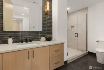 Lower lever 3/4 bath off rec room with mud set tile shower and designer heated stone floors