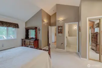 Primary suite enjoys view of the river, ensuite bath, his-hers closets, and vaulted ceiling!