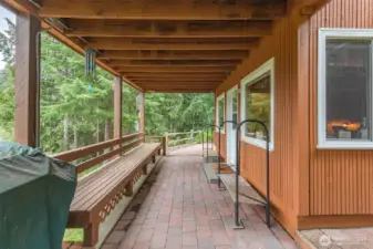 This generous covered patio is wonderful for entertaining all year long, and easily accessible after snowmobiling. The door enters the lower level family room which features the snowmobiling mud room.