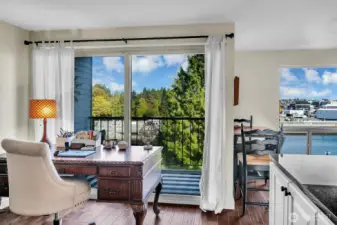 Sunlight pours through the expansive sliding door, leading to a covered deck where you can unwind and watch boats glide along the water.