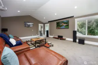 Recreation room with vaulted ceilings & door to the yard.