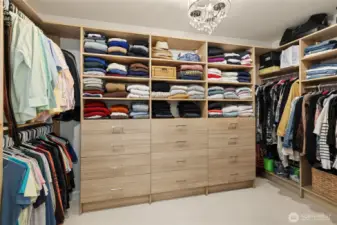Primary walk in closet with custom organization.