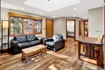 Family room with a large skylights and a wall of windows creates an inviting area to relax.