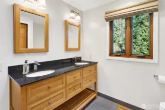 Primary bath beautifully remodeled with radiant floor tile flooring with a stone glass shower.