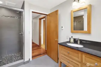 Primary bath with stone tiled shower with dual vanity.