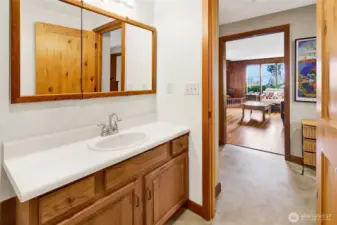 Hallway full bathroom with medicine cabinet mirror. Vinyl flooring.