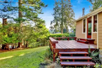 Deck with partial Lake Whatcom Views off the living room with stairs to the side yard.