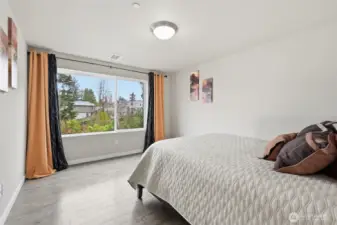 Spacious primary bedroom with view to green space