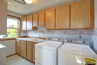 Huge laundry room w/ utility sink, window & tons of storage. Newer washer & dryer.