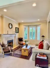 Living room with bay window and gas fireplace.