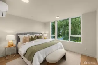 This inviting bedroom is framed by windows and natural textures, creating a peaceful vibe day and night.