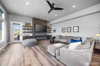 Living room with statement electric fireplace and floor to ceiling stone.