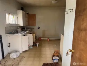 Kitchen from back entry view, bathroom off to the right