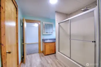 Bathroom with shower/tub combo. New flooring and newer cabinets.