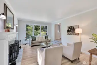 Living room has a beautiful window & marble fireplace