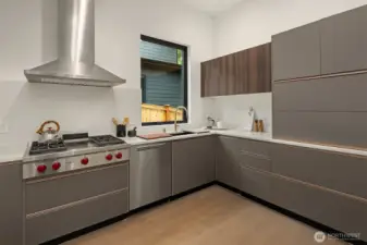 The dedicated spice kitchen features a Wolf gas cooktop with hood.