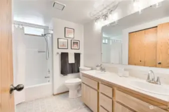 Downstairs bathroom with dual sink vanity & large linen closet