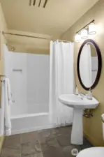 Main level full bathroom with heated slate tile floors.