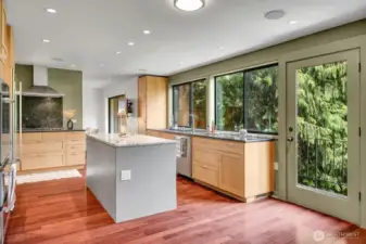 Kitchen with granite counters and Brazilian cherry hardwood floors opens to a deck overlooking the back patio and Allen Creek.
