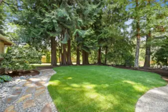 Fully Fenced Backyard features slate path leading to gardending shed