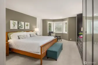 Primary ensuite boasts abundant natural light, bay windows, ample storage with built-in cabinets lined with shelves, and a built-in dresser all spanning the entire wall.